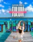 Una turista con sombrero caminando sobre un muelle de madera hacia el letrero gigante de Tulum en las aguas turquesas de la Laguna Kaam Luum.